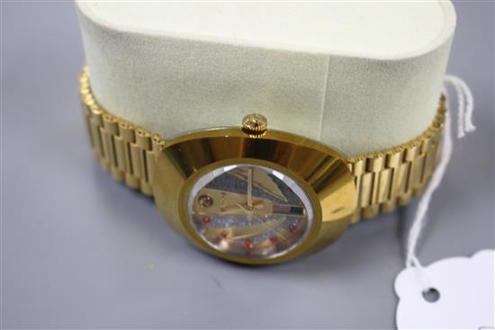 A gentlemans gilt steel Rado Diastar automatic wrist watch, with red stone set markers and textured dial, on Rado bracelet.